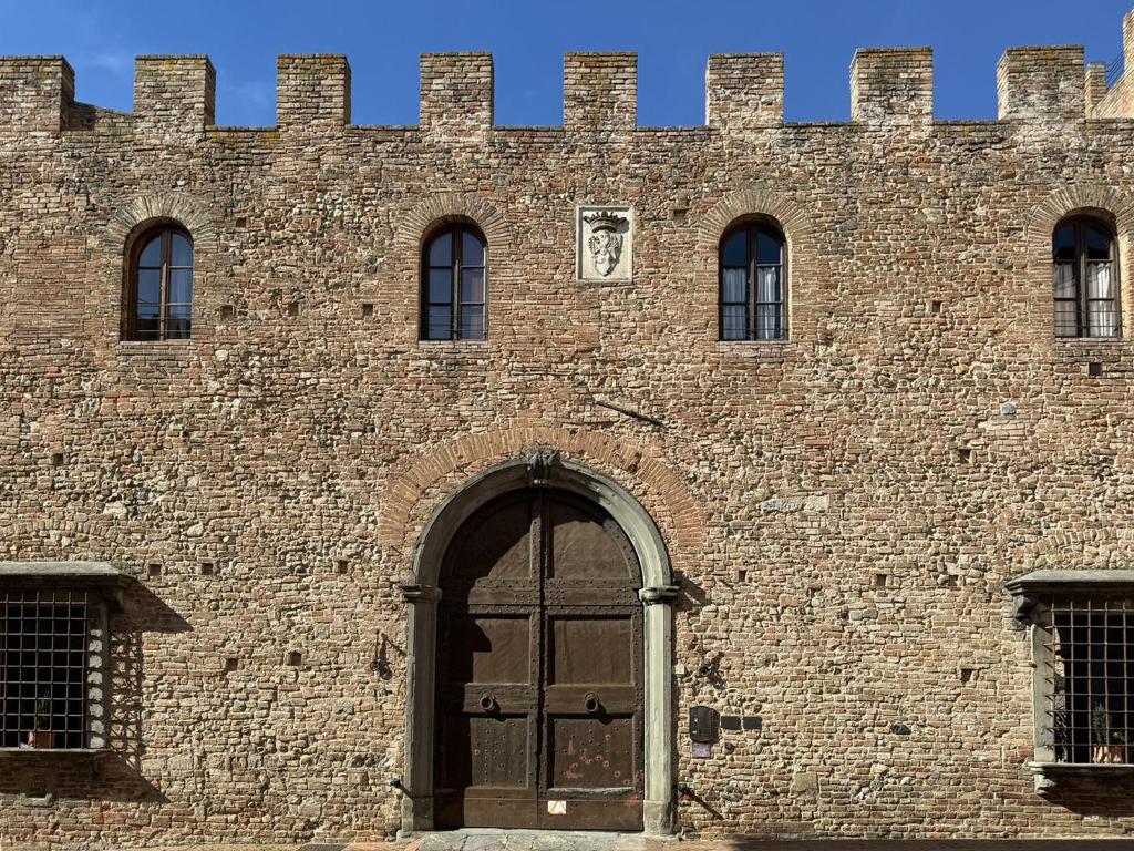 un grande edificio in mattoni con una grande porta e un edificio di Suite Gabri, Stiozzi Ridolfi a Certaldo