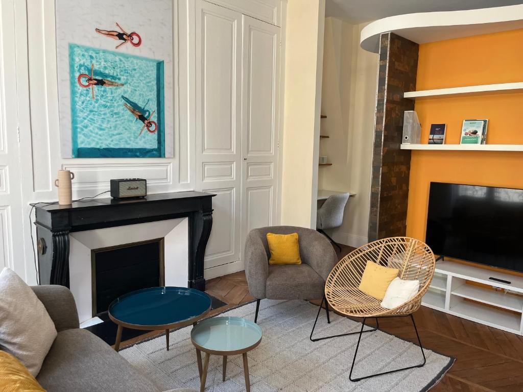 een woonkamer met open haard en tv bij Une escapade au cœur de Tours in Tours