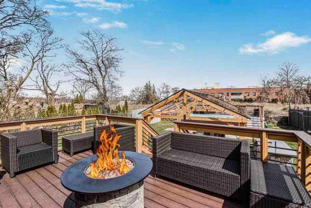a patio with couches and a fire pit on a deck at Entire home- pool, gym, theater. 10 min from NYC. in Yonkers