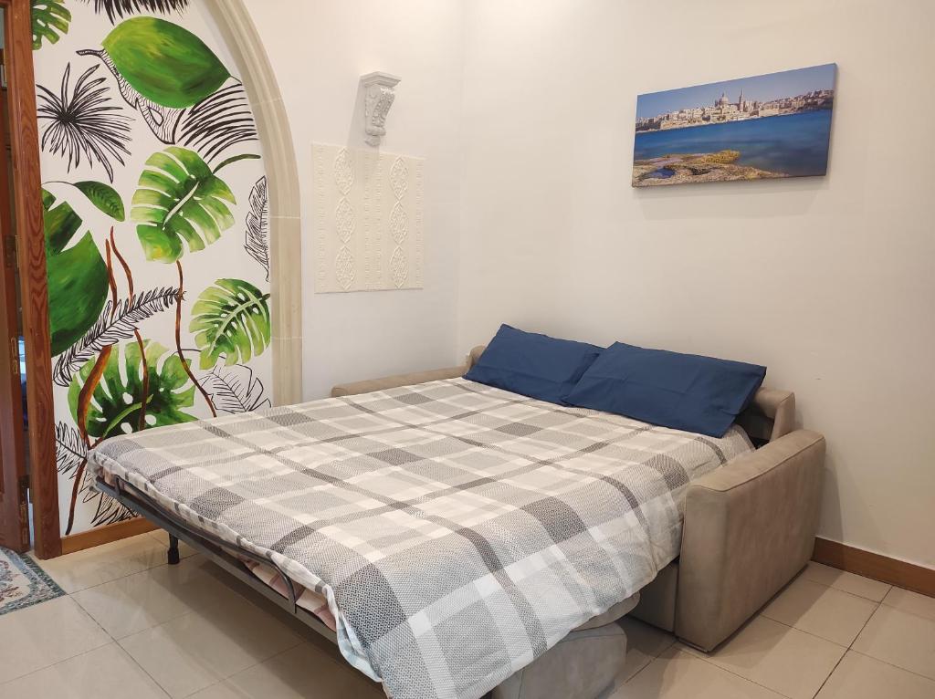 a bedroom with a bed with a plaid blanket at Ta' Marija Home in Sliema