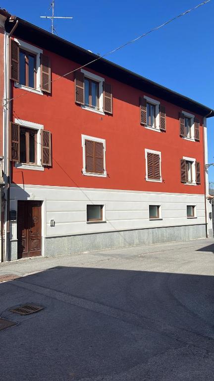 a red and white building on the side of a street at Palazzo Rosso in Lesegno
