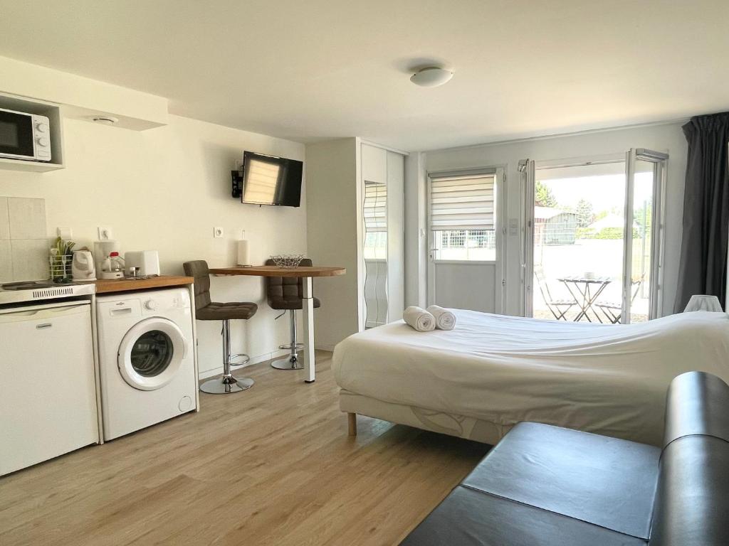 een slaapkamer met een bed en een wasmachine bij Studio calme, la campagne a 5 minutes de la ville in Fondettes