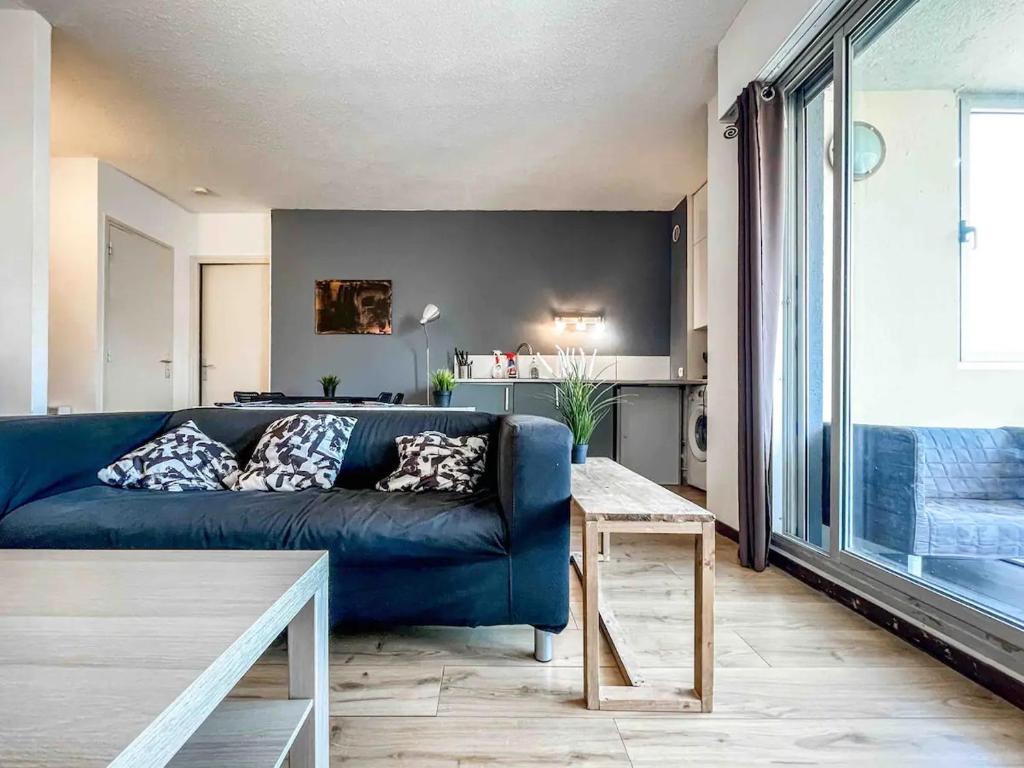 un salon avec un canapé bleu et une table dans l'établissement Petit bijou, à 2 pas de la gare et du centre ville, à Sète