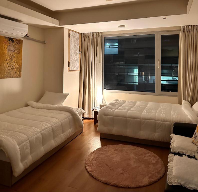 sala de estar con 2 camas y ventana en #강남역 3분#편리한 교통#편안한 숙소, en Seúl