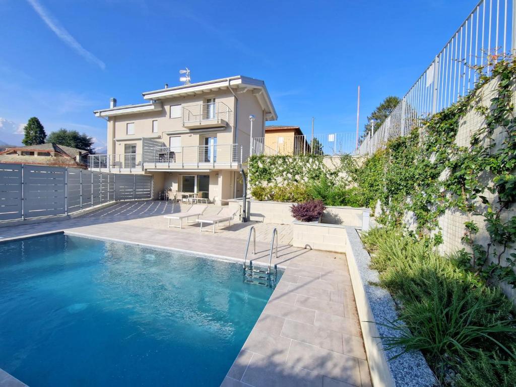 a house with a swimming pool in front of a house at VILLA CLAUDIA WITH PRIVATE POOL in Colico