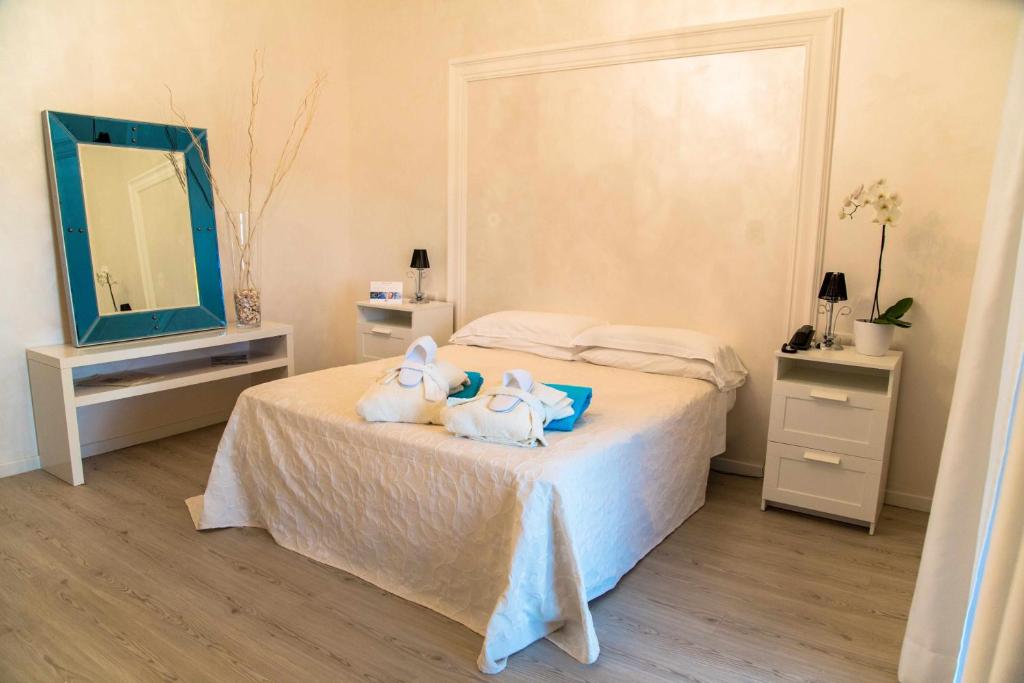 una camera da letto con due asciugamani su un letto con specchio di Bellavista Terme Resort & Spa a Montegrotto Terme
