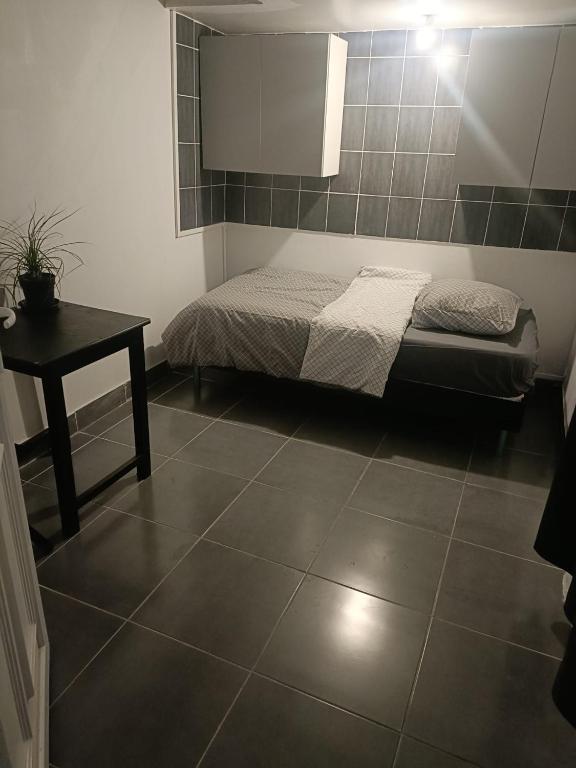 une chambre avec un lit et une table dans une pièce dans l'établissement Tiny house - Gare Paris Aeroport, à Drancy