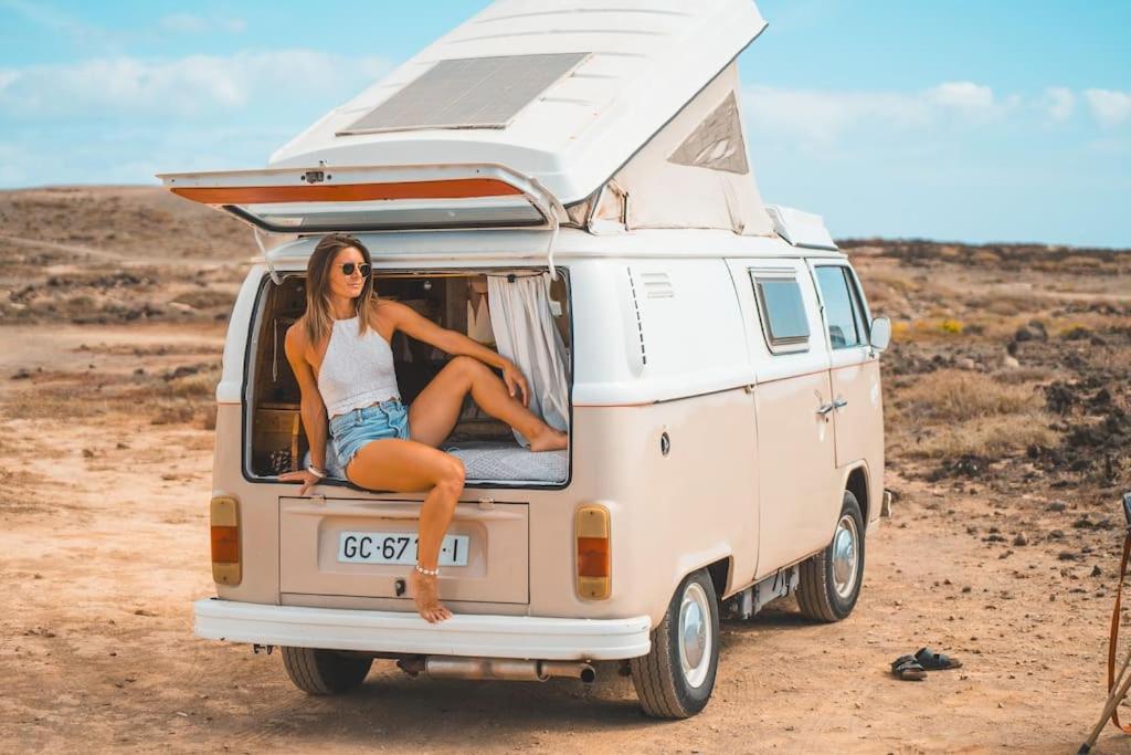 una mujer sentada en la parte trasera de una furgoneta blanca en Tommy, a '77 VW Bay stylish Van, en Los Cristianos