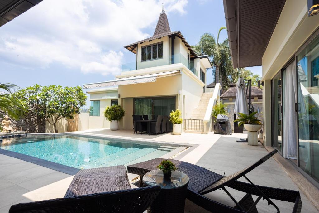un patio al aire libre con piscina y una casa en 4BDR luxury pool villa & office space in Cherngtalay-Bangtao en Ban Phru Champa