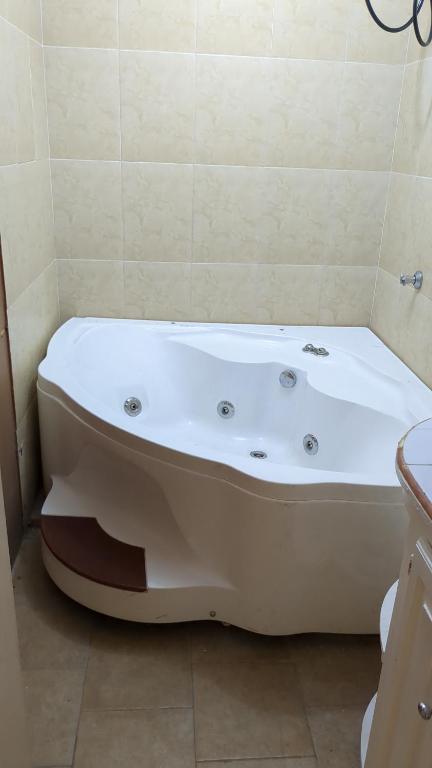een badkamer met een wit bad en een wastafel bij BridgeView Arcadia in Portmore