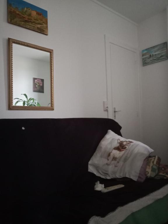Schlafzimmer mit einem Bett und einem Wandspiegel in der Unterkunft Super in Gennevilliers