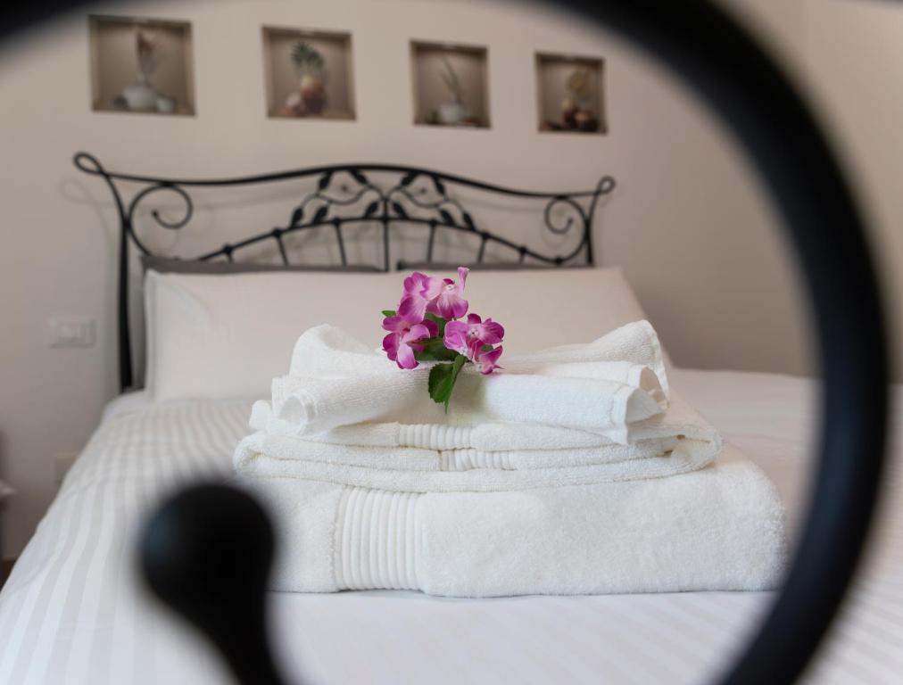 uma pilha de toalhas e uma flor numa cama em Casa Martina Tuscany em Certaldo