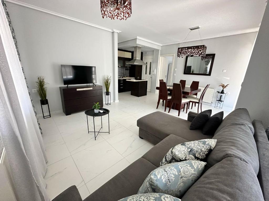 a living room with a couch and a dining room at Eden Suite Paralia in Paralia Katerinis