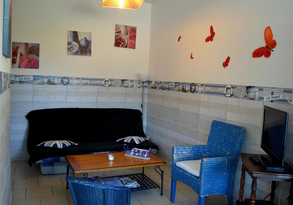 a living room with a couch and a table and chairs at Gîte Les Vents du Large Vanneau Huppé in Le Crotoy