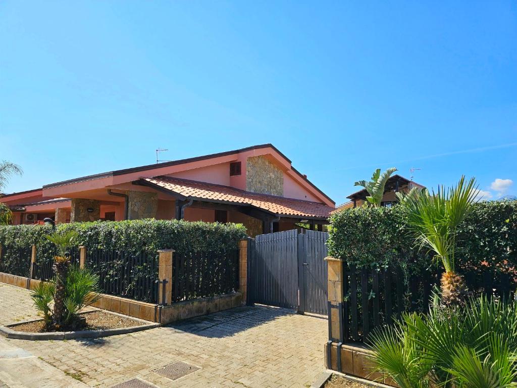ein Haus mit einem Zaun davor in der Unterkunft Costa Mediterranea Holiday Homes in Campofelice di Roccella