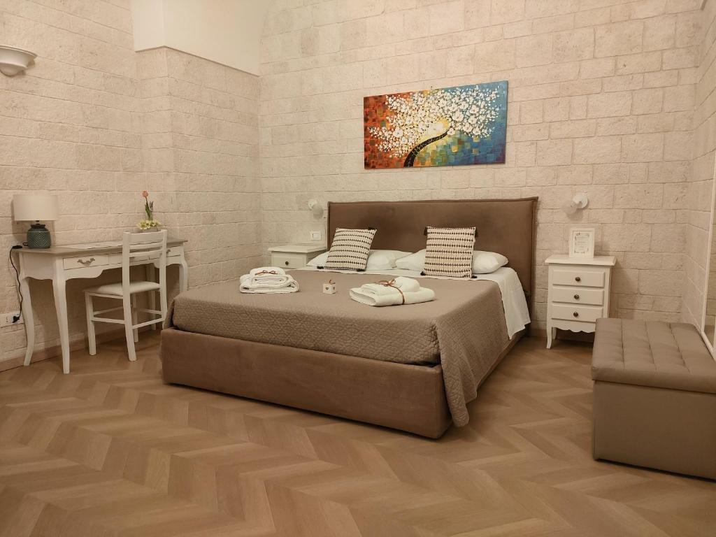 una camera con letto, scrivania e quadro di Dimora della Nonna a Mola di Bari