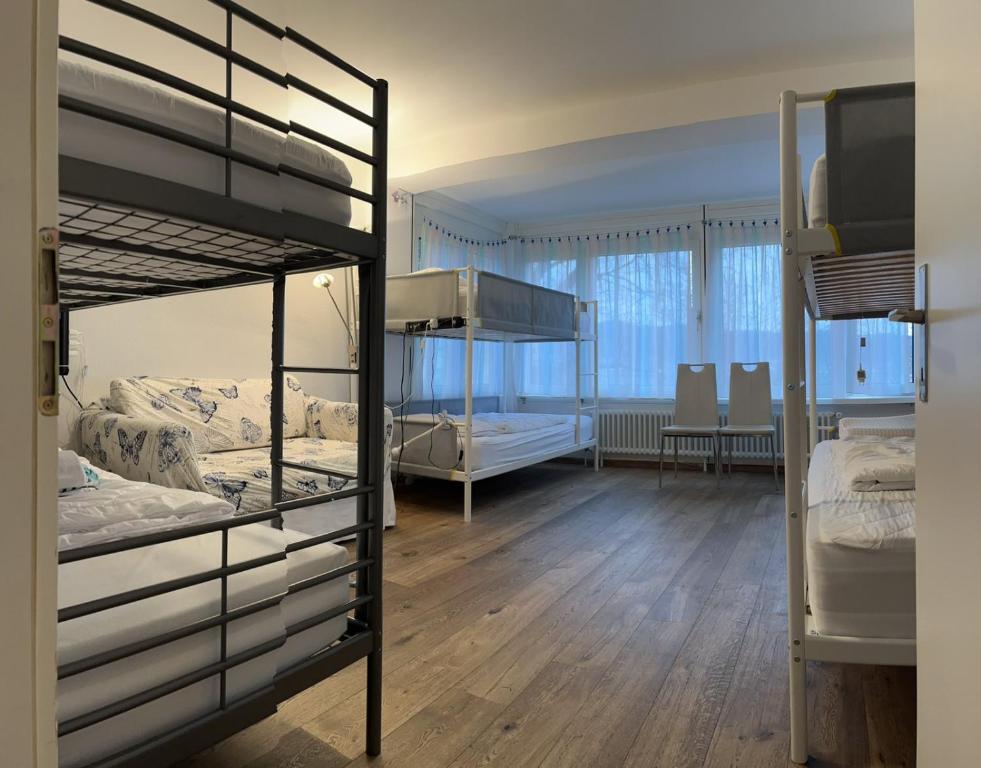 a room with two bunk beds and a dining room at Viktoria Budget Hostel in Zurich