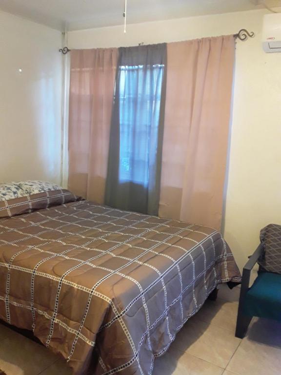 1 dormitorio con 1 cama, 1 silla y 1 ventana en Errol and Nancy Place, en Nassau