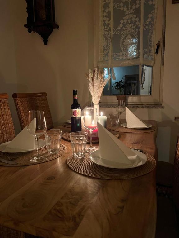 a wooden table with a bottle of wine and glasses at Ferienwohnung Nispel in Limburg an der Lahn