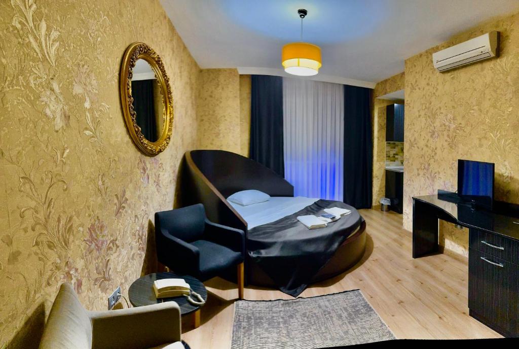 a living room with a black chair and a mirror at Bossuite Hotel Maltepe in Istanbul