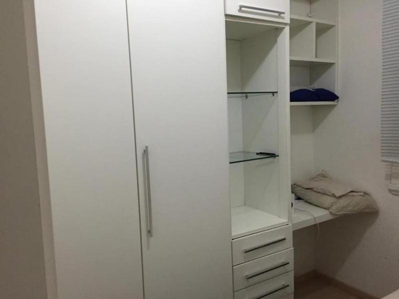 um armário branco com prateleiras brancas e um frigorífico em Quarto no posto 5 de Copacabana no Rio de Janeiro