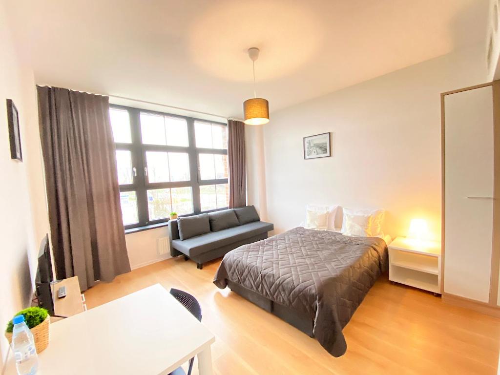 - une chambre avec un lit, un canapé et une table dans l'établissement Apartimento Hydral Fresco, à Wrocław