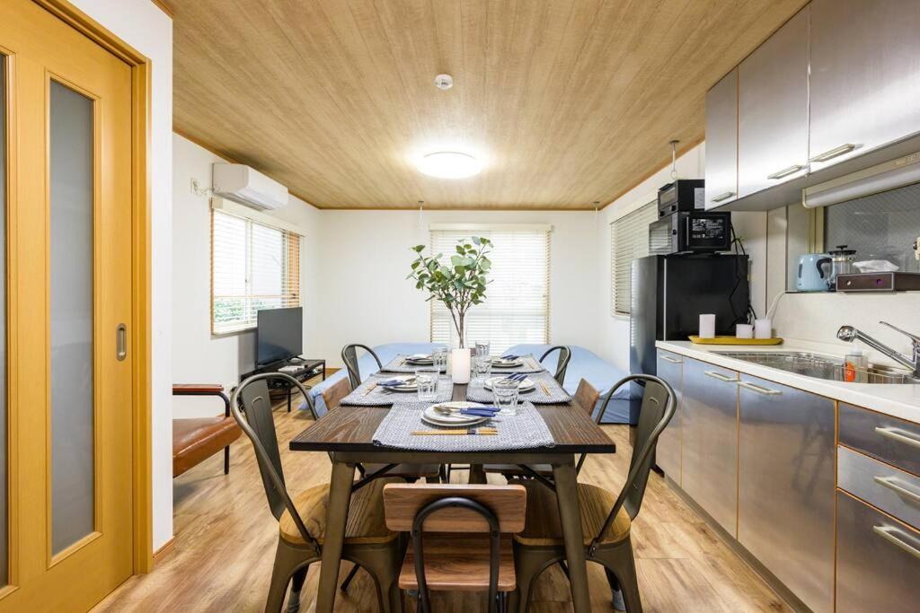 cocina y comedor con mesa y sillas en Premier suite Yoyogi front detached house, en Tokio