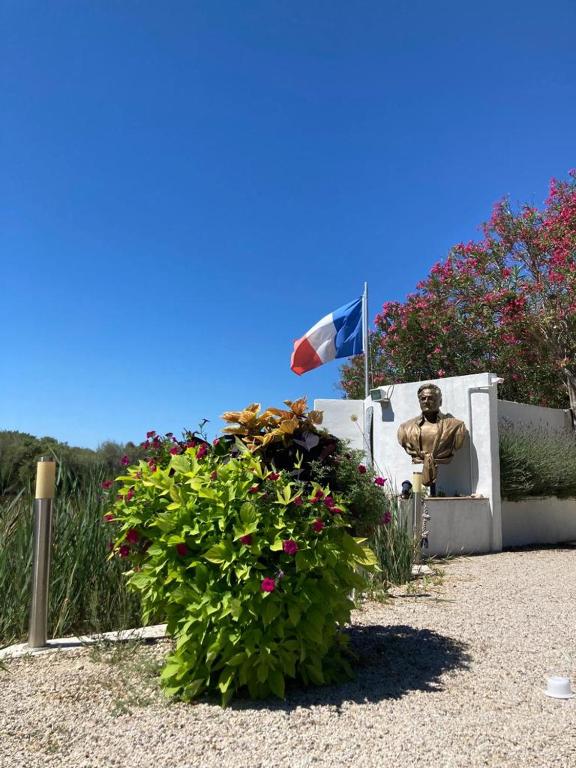 a statue of a man with a flag and flowers at Mas de la pie in Saintes-Maries-de-la-Mer