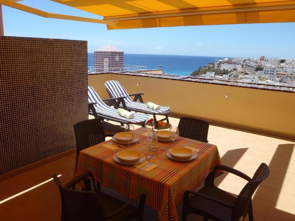 una mesa en un balcón con vistas al océano en Komfortable Ferienwohnung in Morro Jable mit Großer Terrasse und Neben dem Strand en Morro del Jable