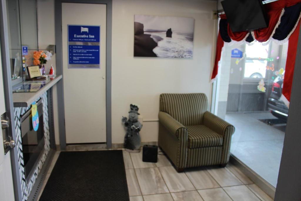 sala de estar con silla y boca de incendios en Executive Inn, en Owatonna