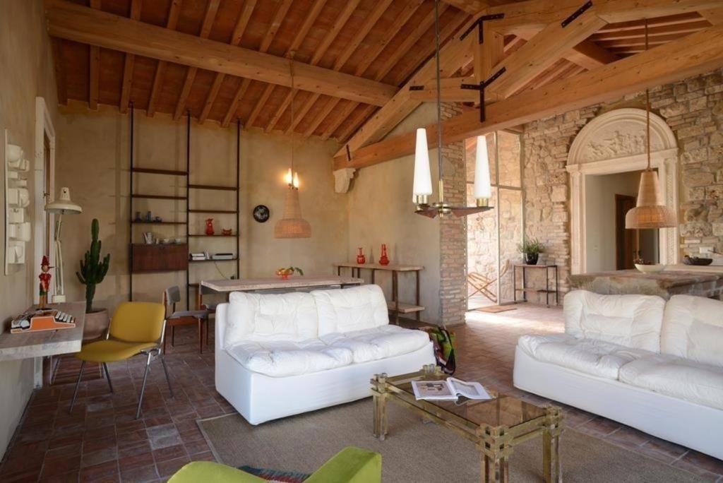 ein Wohnzimmer mit 2 weißen Sofas und einem Tisch in der Unterkunft Wohnung in Volterra mit Gemeinsamem Garten in Volterra
