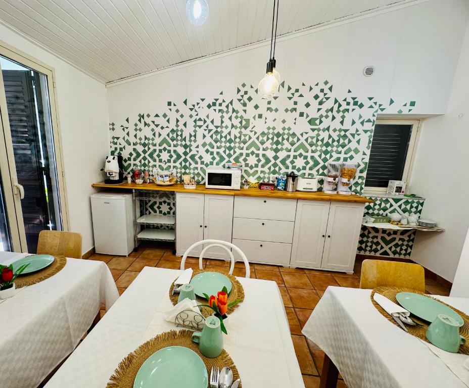 a kitchen with tables and chairs and a kitchen with a counter at Casa Lilla in Monreale