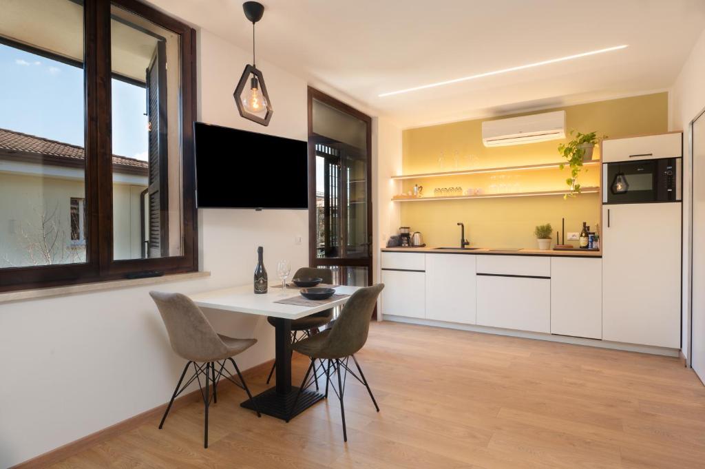 a kitchen with a table and chairs in a room at Wohnung am Strand mit Pool in Sirmione