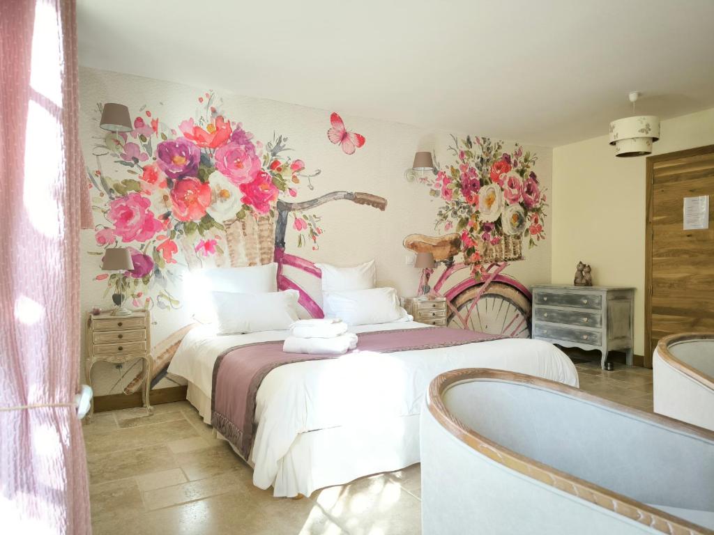1 dormitorio con 1 cama con flores en la pared en La Grange de Moisey, en Marigny-lès-Reullée
