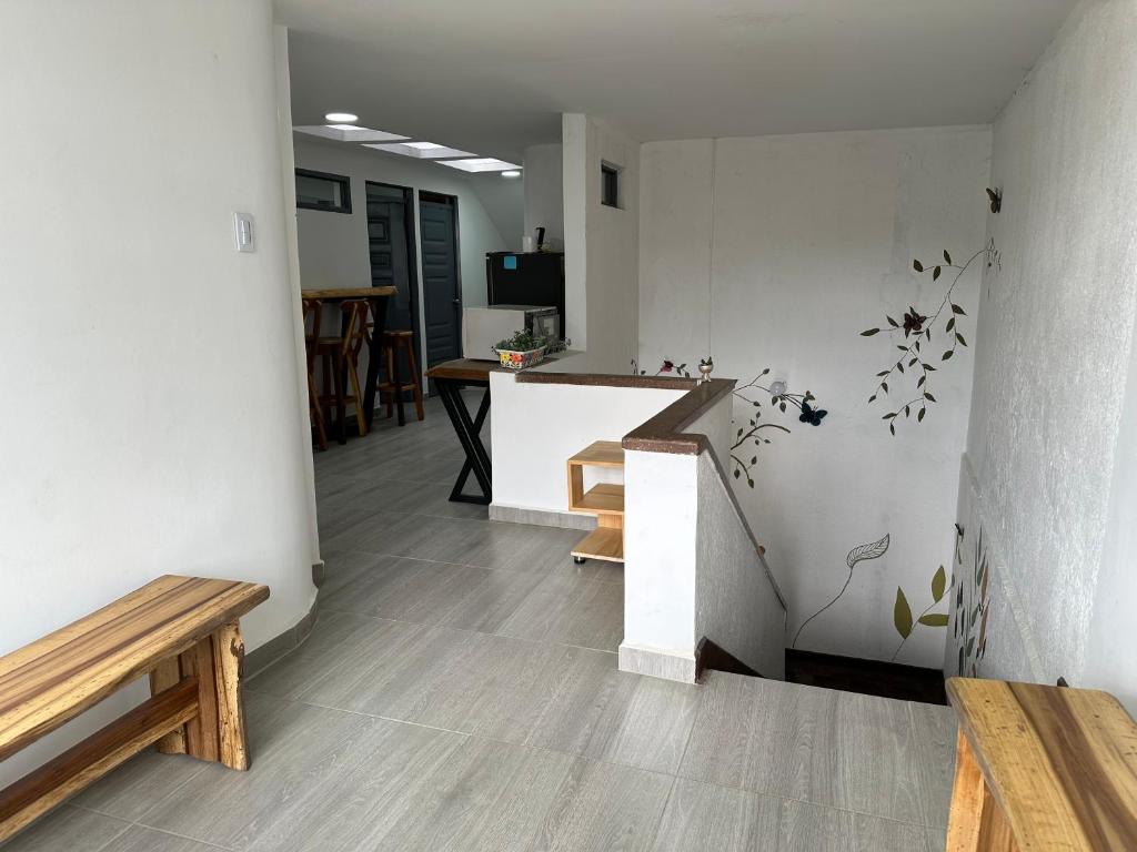 a room with a counter and stairs with a bench at Hostal Pajuil in Armenia
