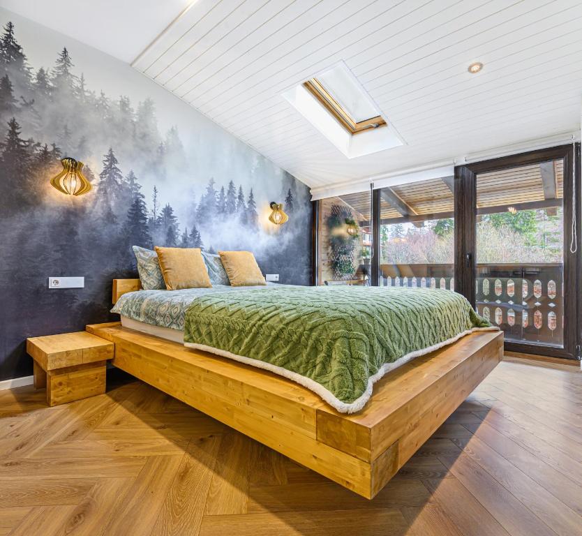 a bedroom with a bed with a forest mural on the wall at Studio Guapo in Poiana Brasov