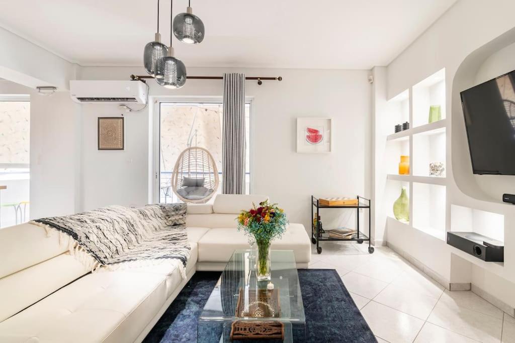 ein Wohnzimmer mit einem weißen Sofa und einem Glastisch in der Unterkunft Modern Apartmen, Piraeus near Microlimano, Kastela in Piräus