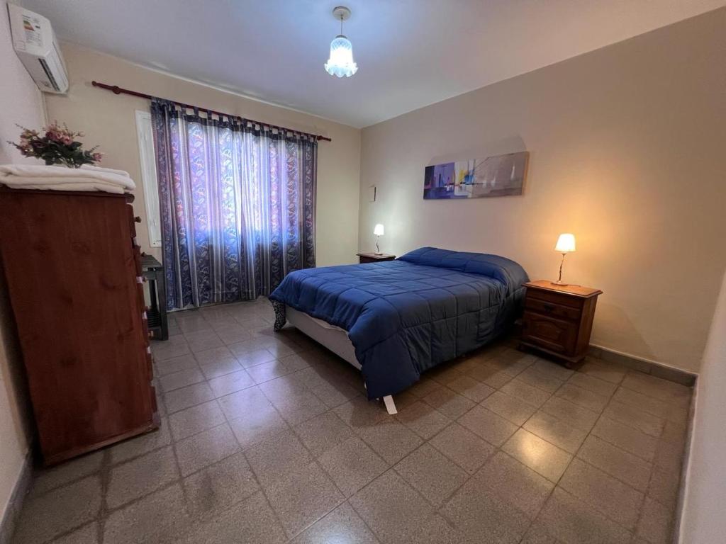 Un dormitorio con una cama azul y una ventana en Casa Felisa en San Salvador de Jujuy