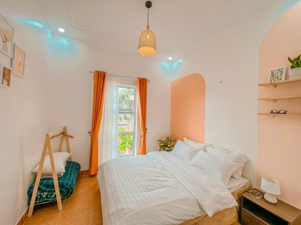 1 dormitorio con cama blanca y ventana en Nhà Của Bối - Villa Mộc Châu en Mộc Châu