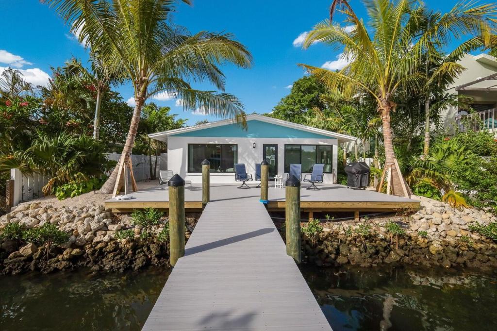 a house on the water with a dock and palm trees at The Bea's Knees home in Anna Maria