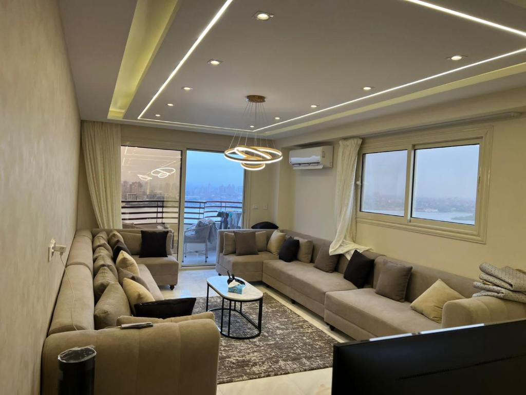 - un salon avec un canapé et une table dans l'établissement Nile view 3 full bedroom apartment, au Caire