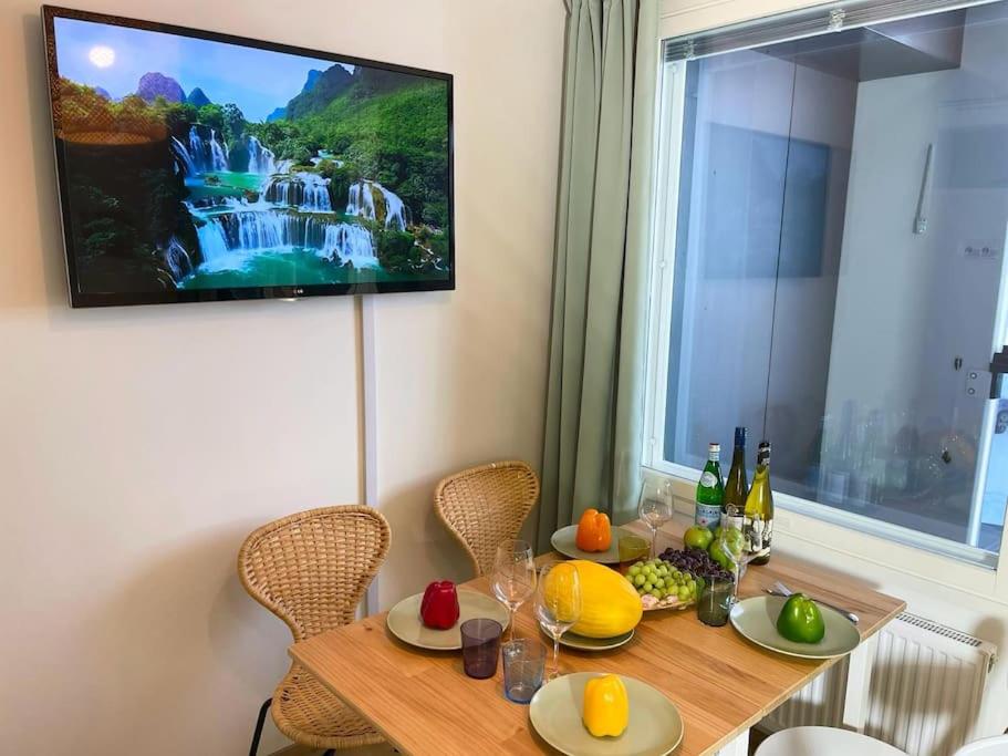 stół jadalny z telewizorem na ścianie w obiekcie Docent's Flat w mieście Joensuu
