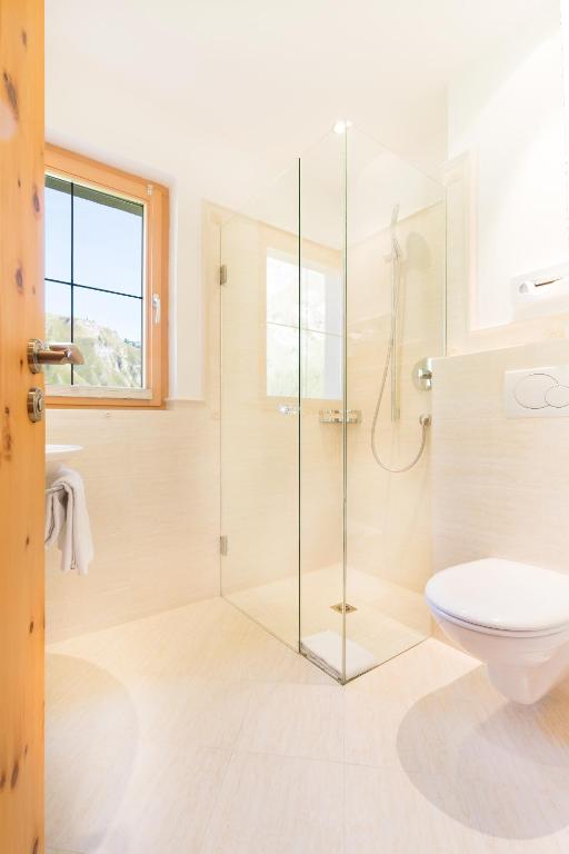a bathroom with a glass shower and a toilet at Chasa Castello relax & spa in Samnaun