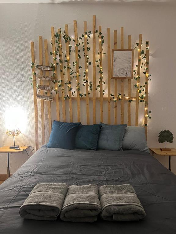 a bed with a wooden headboard with lights on it at Appart'hôtel PrestigeHost in Orléans