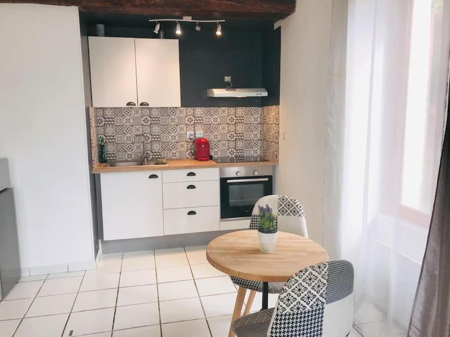 a kitchen with a table and two chairs and a table at Studio douillet proche de la gare SNCF et du centre in Auxerre