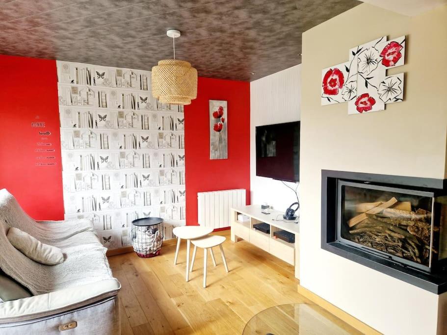 a living room with red walls and a fireplace at Villa Coquelicot YourHostHelper 
