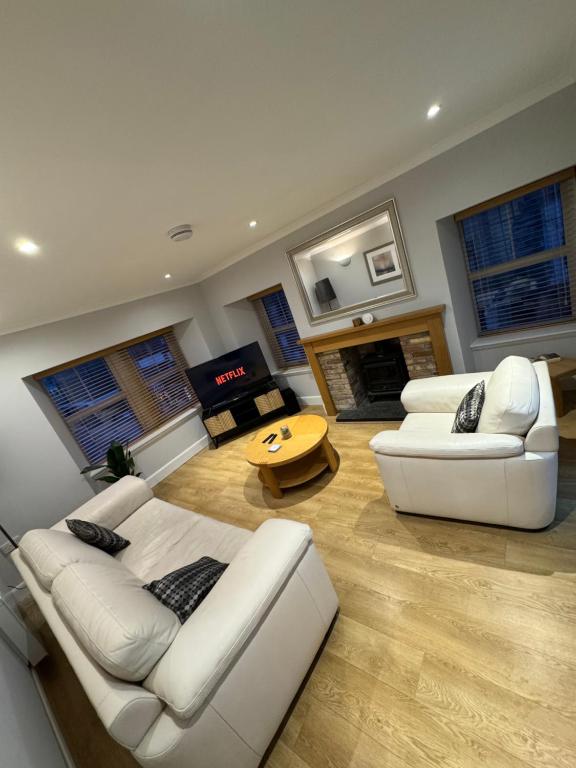 a living room with two white couches and a table at Town Centre 2 bedroom apartment in Wick