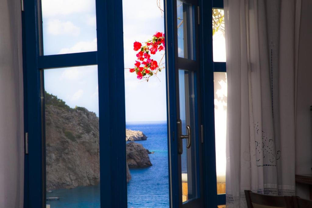 um quarto com uma janela com vista para o oceano em Blue Waves Studios em Kyra Panagia