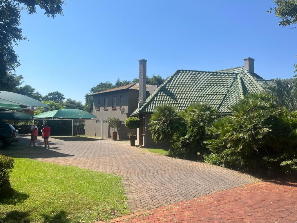 a brick walkway in front of a house with palm trees at 999 Pretorius street in Pretoria