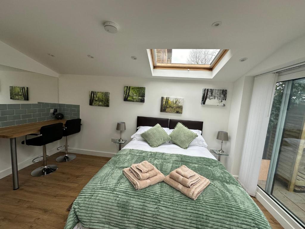 a bedroom with a bed with two towels on it at Little Hawthorns in New Alresford